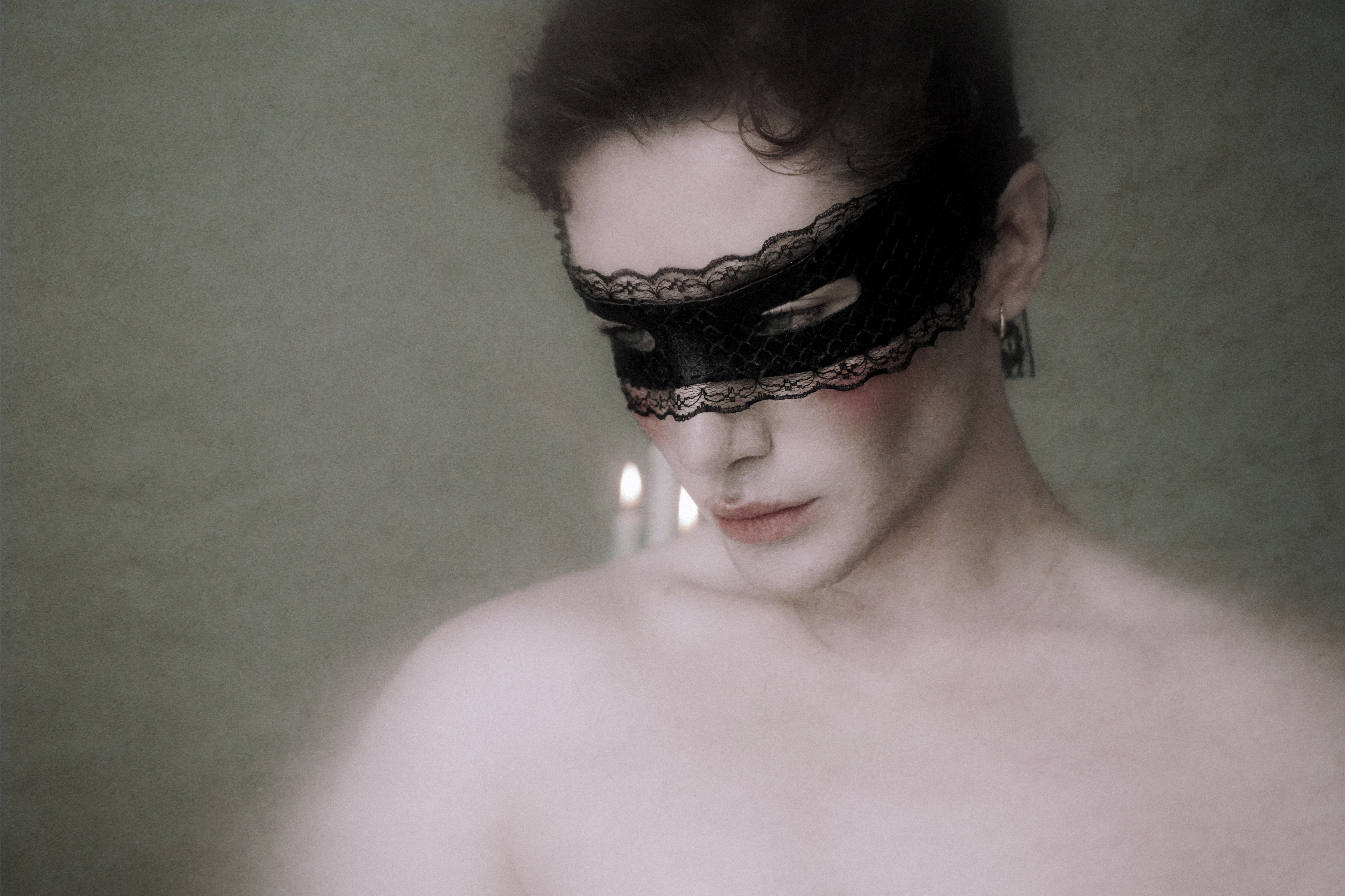 Figure in lace mask by candlelight